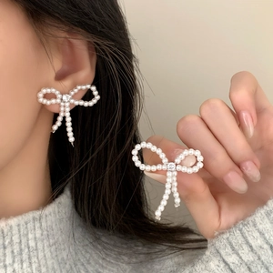 Boucles d'oreilles nœud en perles élégantes avec perles blanches et zircon central étincelant