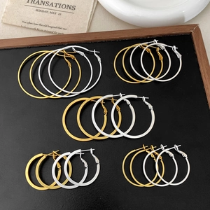 Minimalist matte geometric hoop earrings in gold and silver finish shown on display
