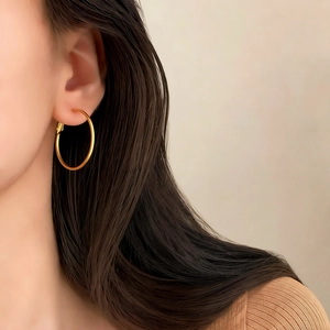 Close-up of a model wearing a polished gold geometric hoop earring for daily style