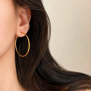 Detailed view of matte gold geometric hoop earrings worn on a model for daily fashion