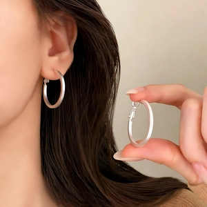 Detail showing matte silver finish and secure clasp of large geometric hoop earrings