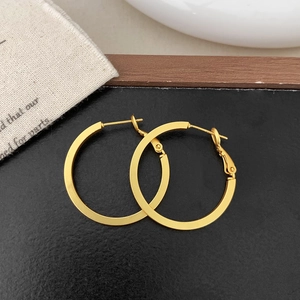 Macro view of minimalist matte gold geometric hoop earrings with polished finish