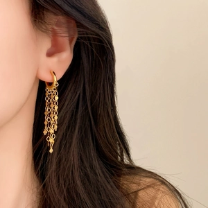Boucles d'oreilles créoles dorées 18 carats avec chaînes à franges sur mannequin