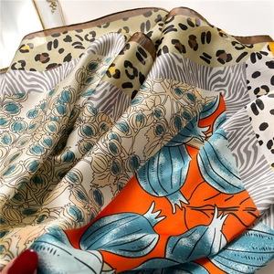 Detail of silk scarf showing leopard print patterns and smooth rolled edge texture