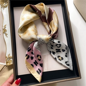 Detail of silk satin scarf with leopard print and floral patterns in a luxury gift box