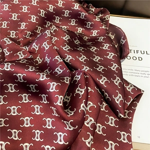 Luxurious deep burgundy silk scarf with classic triomphe pattern in a stylish folded layout