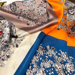 Satin silk scarf with orange and blue paisley print for sun protection and style