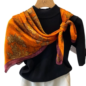 Floral silk square scarf with vintage orange pattern on black turtleneck sweater