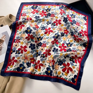 Detail of floral silk square scarf with colorful blossoms and a navy blue border