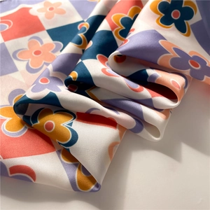 Detailed view of silky satin scarf with vintage floral checkerboard pattern and smooth sheen