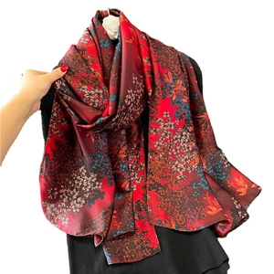 Luxurious long silk scarf with vibrant floral print in red and deep blue tones