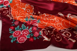 Détail macro d'un foulard en satin aux motifs de roses roses et de vignes sur fond bordeaux