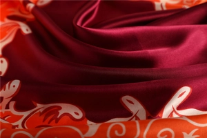 Gros plan sur un foulard en satin bordeaux avec texture lisse et motifs de fleurs vintage