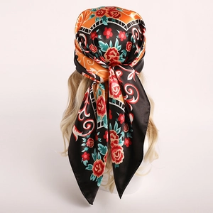 Carré en soie satinée avec motifs de roses rouges porté comme un foulard élégant