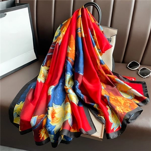 Close-up of luxury lotus pond floral print scarf draped on a leather handbag