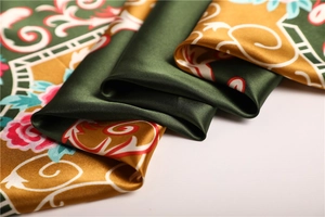 Vue détaillée du tissu satiné brillant avec motifs floraux vintage et bords géométriques