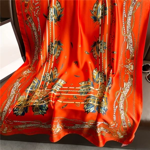 Close-up of luxury orange silk scarf with vintage leaf patterns and rope prints