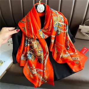 Detail of luxury orange silk scarf featuring equestrian chain print and satin finish