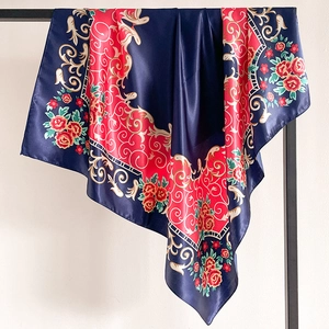 Détail d'un foulard en satin aux motifs baroques et floraux bleu marine et rouge