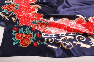 Détail d'un foulard en satin à texture de soie aux motifs de roses bleu marine et rouge