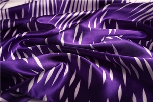 Macro shot of dark purple satin scarf showing white spindle stripes and rolled hem texture