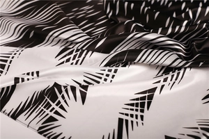 Detailed view of black and white geometric print satin scarf with soft silk texture