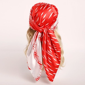 Detail of red satin scarf with white abstract print and fine hemmed edges on model