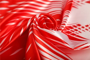 Close-up of smooth satin scarf with red ink patterns and silky texture folds