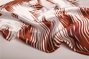 Detail of satin silk scarf showing abstract rust red ink pattern and soft drapery