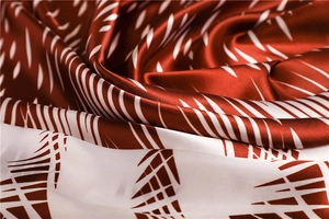 Detailed macro view of the silky fabric texture with red and white abstract pattern