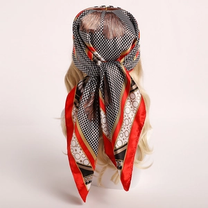 Detail of red and black houndstooth silk scarf with tassel print tied as headscarf