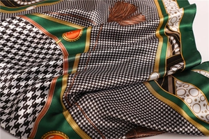 Detailed close-up showing the smooth satin texture and houndstooth pattern of the silk scarf
