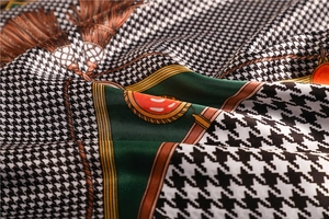 Detail of silk satin scarf showing houndstooth patterns and classic tassel chain prints