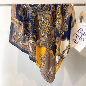 Silk-feel square scarf with classic paisley patterns in navy blue and yellow colors