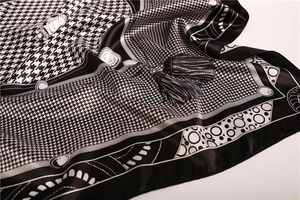 Close-up of silk-like houndstooth scarf with black tassel accents and geometric patterns