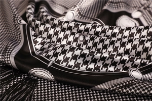 Macro shot of satin houndstooth silk scarf showing elegant texture and glossy fabric folds