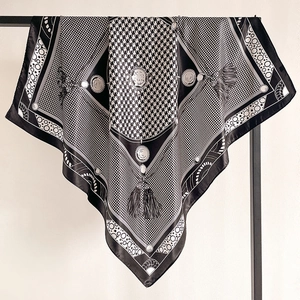 Macro detail of houndstooth silk scarf showing elegant fringe and smooth satin texture