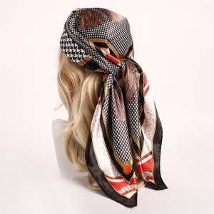 Detail of elegant houndstooth silk scarf with tassel print worn as a chic headpiece