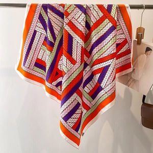 Detailed view of colorful geometric print silk scarf with luxury weave pattern texture