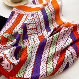 Close-up of multicolored chain print silk scarf with smooth satin texture and vivid colors