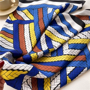 Detail of printed silk square scarf featuring bold rope patterns and vibrant color blocks