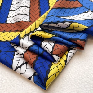 Detail of color-block geometric print silk scarf with luxury woven twist pattern texture
