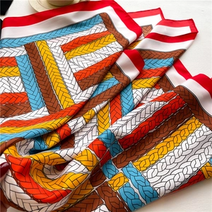 Macro shot of silk scarf fabric showing twist rope print and vibrant color blocks