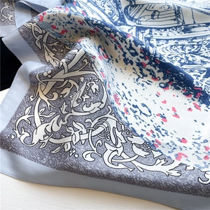 Detail of floral silk scarf featuring elegant baroque patterns and smooth twill texture