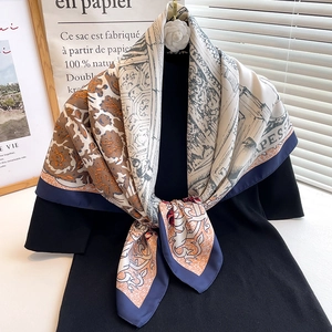 Detail of floral twill square scarf draped over black dress with classic print patterns