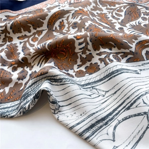 Macro view of floral pattern and silky texture on a large square neck scarf