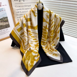 Detail of a patterned silk square scarf featuring geometric prints and refined edging