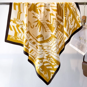 Macro detail of silk scarf showing vintage sun emblem and calendar numbers on satin fabric