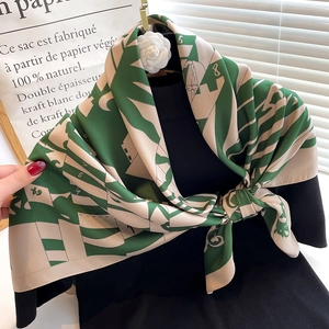 Elegant emerald and white silk scarf with geometric prints and camellia brooch