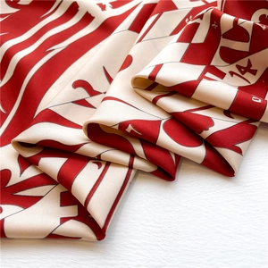 Detail of red and white silk scarf showing smooth satin texture and digital print